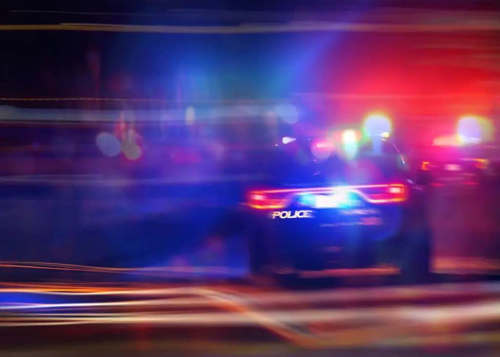 Police car chasing a car at night. 911 Emergency response police car speeding to scene of crime. Selective focus