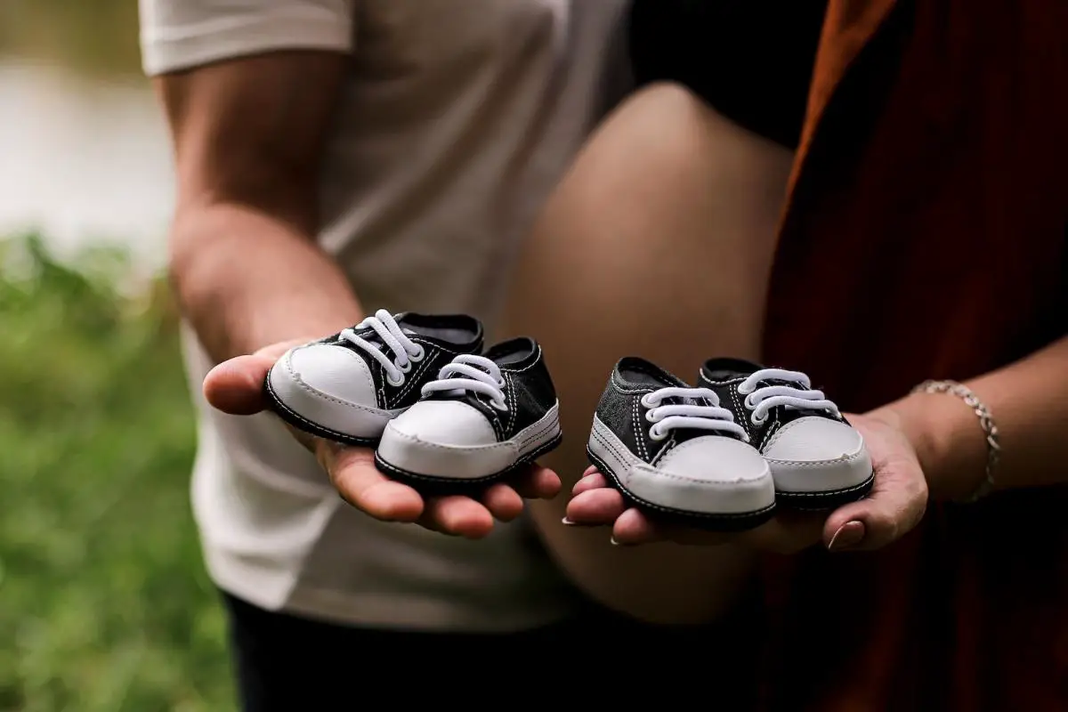 a person holding two baby shoes in their hands